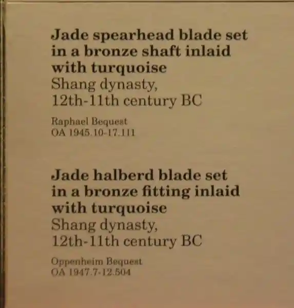 Four swirls around a circle forming a cross on a jade spearhead blade set in a bronze shaft inlaid with turquoise